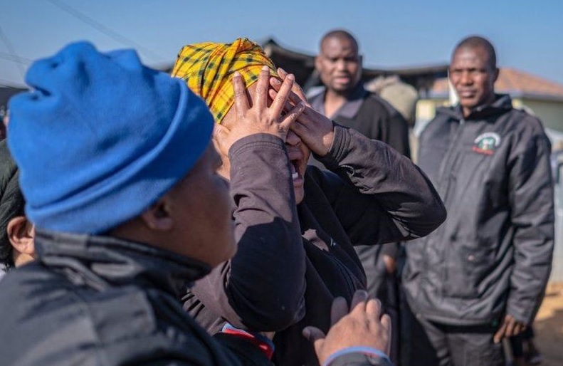 Mourners grieve after a shooting at a bar in Soweto