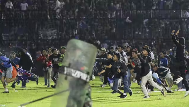 Fans spill on to the pitch during the soccer match in Indonesia
